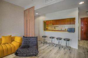 un soggiorno con divano giallo e sgabelli da bar di Water surrounded beautiful 2BR apartment a Ras al Khaimah