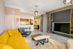 un soggiorno con divano giallo e tavolo di Water surrounded beautiful 2BR apartment a Ras al Khaimah