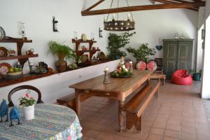 uma sala de jantar com uma mesa de madeira e um banco em Quinta da Fontoura em Alquerubim