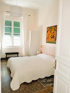 a white bedroom with a bed and a window at I MUSETTI in Genoa
