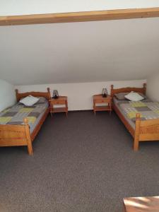 two twin beds in a room with two tables at Ferienwohnung Schmidt in Bayerisch Eisenstein