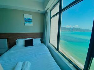- une chambre avec un lit et une grande fenêtre dans l'établissement Ocean Dream Apartment Nha Trang, à Nha Trang