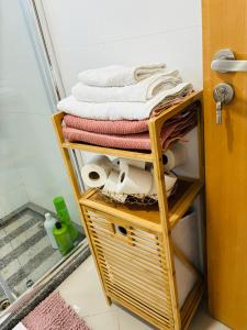 a shelf with towels and towels on it in a bathroom at Techas Near Beach Apt with Pool in Praia