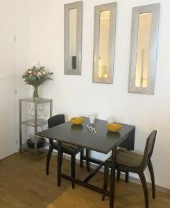 a dining room with a table and chairs and mirrors at Studio bord de Creuse in Argenton-sur-Creuse