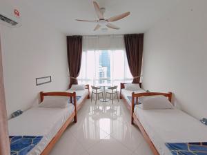 a room with four beds and a ceiling fan at Habibi HoMe KLCC in Kuala Lumpur
