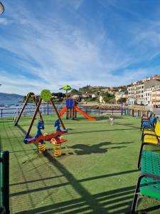 um parque infantil com escorregas e baloiços na praia em Apartamento Vistas Olas del Mar & Playa Raxó em Raxó