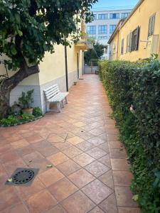 a bench sitting on a sidewalk next to a building at A Casa del Ferdy in Caserta +3 photos