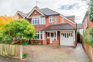 a red brick house with a white garage at 4-bed Retreat, Spacious Oasis With Modern Comfort in Southampton