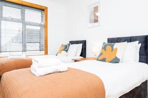 a bedroom with two beds and a window at 4-bed Retreat, Spacious Oasis With Modern Comfort in Southampton