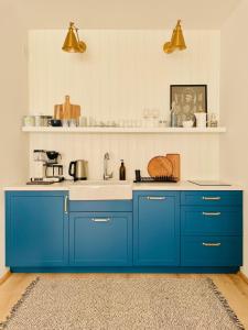 a kitchen with blue cabinets and a sink at 500m Sea, Terrace - Sunny Calm Coastal Retreat in Dźwirzyno