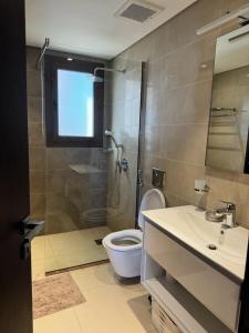a bathroom with a shower and a toilet and a sink at Amazing Apartment in Salalah