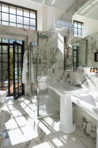 uma casa de banho com 2 lavatórios, uma banheira e um WC. em Vmaison Brera Milano em Milão