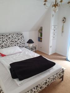 a bedroom with a bed with a black blanket on it at Haus Nadine in Lübeck