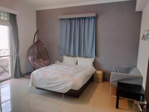 a bedroom with a white bed and a window at 薇琪小屋 in Hualien City