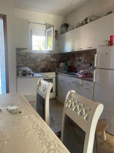 a kitchen with a table and chairs and a white refrigerator at Kadmi in Njeguši