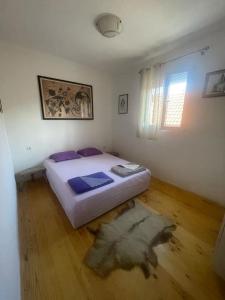 1 dormitorio con 1 cama y suelo de madera en Kadmi en Njeguši