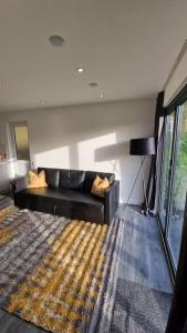 a living room with a couch and a rug at Delightful cabin retreat wrapped by natural beauty in Dartford
