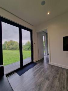 a room with a large window with a view of a field at Delightful cabin retreat wrapped by natural beauty in Dartford