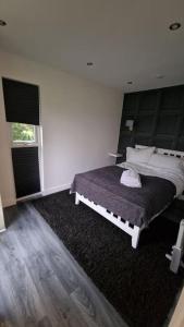 a bedroom with a large bed and a window at Delightful cabin retreat wrapped by natural beauty in Dartford