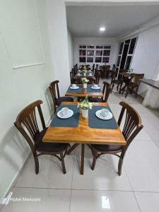 a dining room with wooden tables and chairs at Hotel Manzoni in Campo Grande