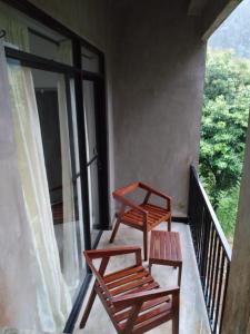 two chairs and a table on a balcony at The Annex By Jansen's Bungalow Sinharaja Rainforest Retreat in Kalawana