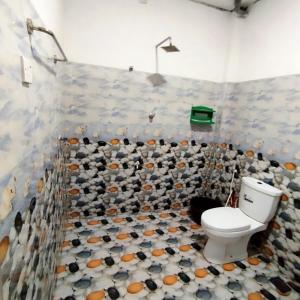 Un baño con inodoro y una pared de azulejos. en Villa lovely birds mirissa, en Mirissa 19 fotos más