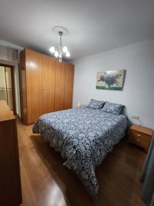 1 dormitorio con 1 cama y armario de madera en Piso equipado a 15min de Sevilla, en San José de La Rinconada