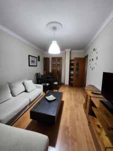 sala de estar con sofá y mesa en Piso equipado a 15min de Sevilla, en San José de La Rinconada