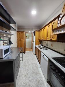 cocina con armarios de madera y encimera en Piso equipado a 15min de Sevilla, en San José de La Rinconada