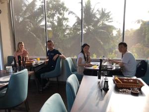 a group of people sitting at tables in a restaurant at Ceylanro Transit Villa in Negombo