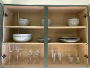 a cabinet filled with glasses and plates and bowls at Kensal Green - Garden Retreat in London