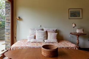 a bedroom with a bed with pillows and a table at Cap de Creus : bungalow, jardin y vista al mar. in Selva de Mar