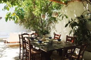 a wooden table with chairs and a tableasteryasteryasteryasteryasteryasteryasteryastery at Traditional Farm House Langada in Patmos