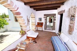 a dog laying on a patio with a couch and a table at Traditional Farm House Langada in Patmos