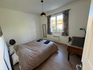 um quarto com uma cama, uma secretária e uma janela em CAPBRETON. Villa BAKENSACK avec terrasse pour 12 personnes wifi gratuit em Capbreton