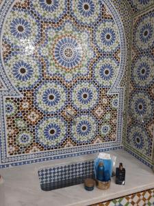 uma parede de mosaico com azulejos azuis e brancos em Dar Al Miraaj em Rabat