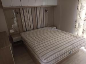 un letto con materasso a righe in una stanza di Détente et confort au Bois Dormant camping 4* MH240 a Saint-Jean-de-Monts