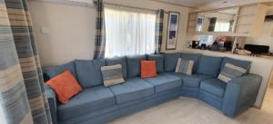 a blue couch in a living room with pillows on it at Détente et confort au Bois Dormant camping 4* MH240 in Saint-Jean-de-Monts