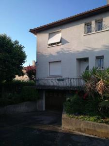 Una casa blanca con un balcón en el lateral. en Chez Margot et Bernard, en Jurançon