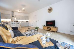 a living room with a blue couch and a tv at City Centre - Luxe 2Bed Palazzo in Manchester