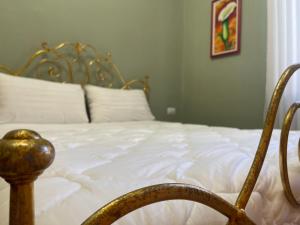 a bedroom with a bed with white sheets and a chair at HOTEL VILA 15 - CENTER in Tirana