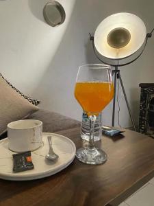 a glass of orange juice sitting on a table with a plate at cristal appart in Essaouira