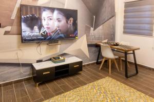 a living room with a flat screen tv on the wall at Petunia Apartment in Accra