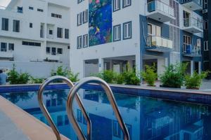 an apartment with a swimming pool and two buildings at 3 bedroom service apartment Victoria Island Aij Residence in Lagos