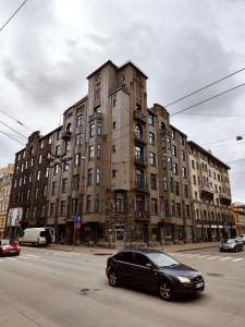 a black car parked in front of a large building at New luxury apartment in the center in Rīga