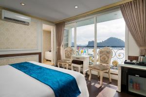 ein Hotelzimmer mit einem Bett und einem Balkon in der Unterkunft Hạ Long Aqua Legend Cruise in Hạ Long