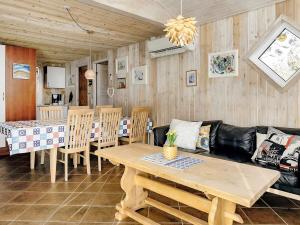 uma sala de estar com uma mesa e um sofá em 9 person holiday home in L kken em Grønhøj