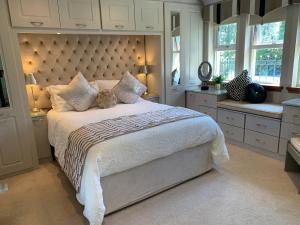 um quarto com uma cama grande e uma grande cabeceira. em Ayrs and Graces - Luxury Bed and Breakfast em Ayr