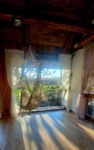 Cette chambre dispose d'un hamac suspendu devant une fenêtre. dans l'établissement Jaśkowa Stodoła, à AdamÃ³w