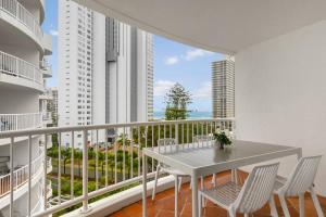 un balcón blanco con mesa y sillas. en 'Haven' Surfers Paradise en Gold Coast